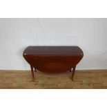 Mahogany oval drop leaf table on turned legs, opening to 128cm x 122cm