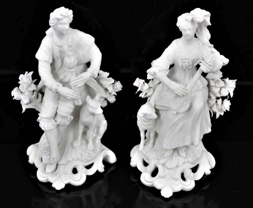 A pair of Derby bisque figures of a shepherd and shepherdess, shown seated on scrolled rococo bases,