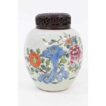 A Chinese famille rose ginger jar and carved wooden cover, 18th/19th century, painted with peonies a