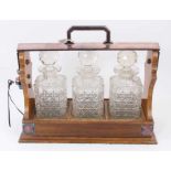 Edwardian oak tantalus with silver plated mounts and three hob-nail cut glass decanters