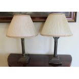 Pair of Victorian-style brass Corinthian table lamps on stepped square bases, with matching silk sha