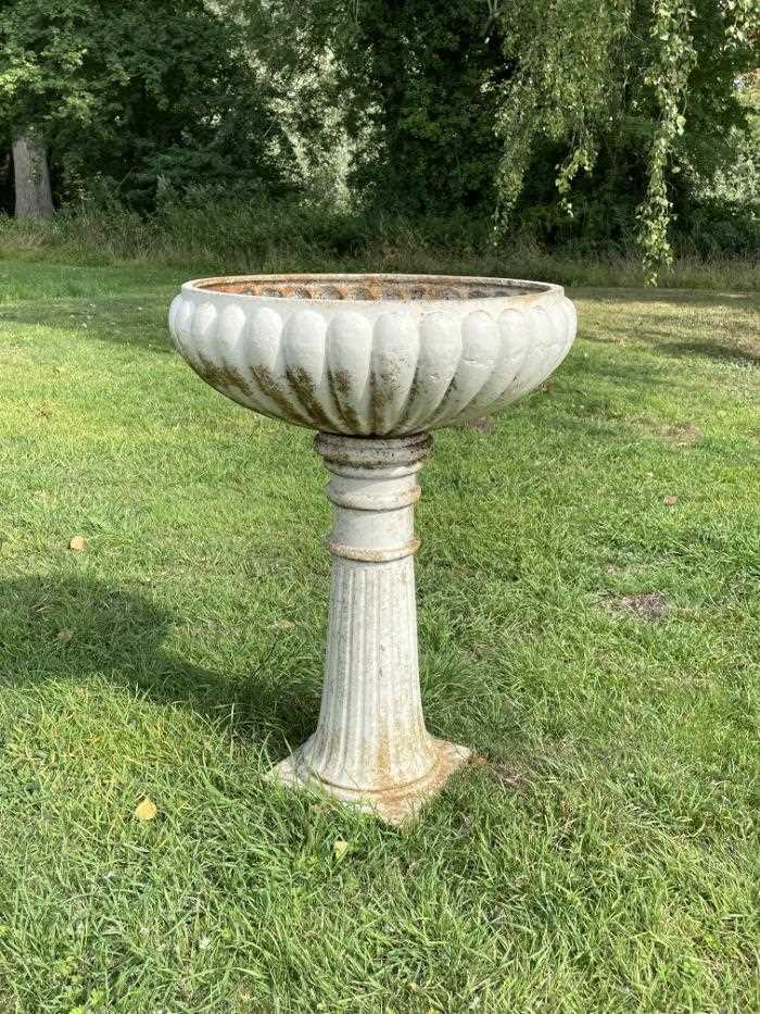 Pair antique white painted cast iron garden planters of lobed compressed form, on fluted splayed col