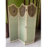 Decorative painted three fold boudoir screen with shield shape caned panels each painted with an ova