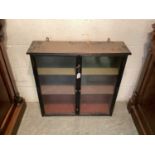 19th century ebonised hanging wall cabinet, the glazed doors enclosing two shelves, 74cm wide x 20cm