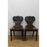 Pair of late Regency mahogany hall chairs, with Etruscan scroll backs and solid seats, on turned and