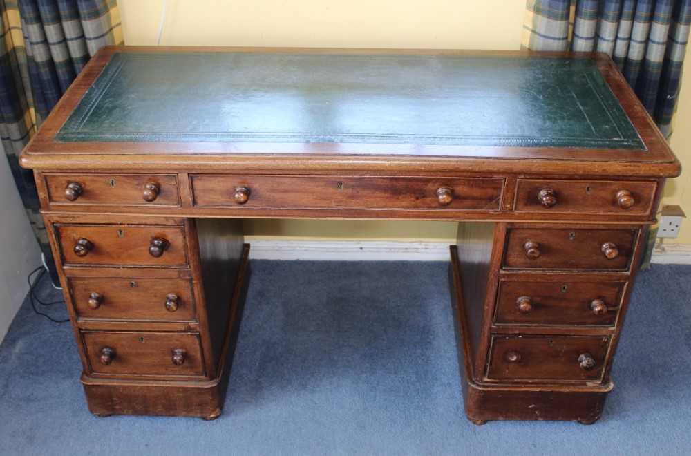 Late Victorian mahogany twin pedestal writing desk with leather lined top above an arrangement of ni