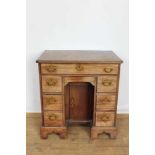 George II mahogany kneehole dressing table, the top with re-entrant angles and seven drawers and flu