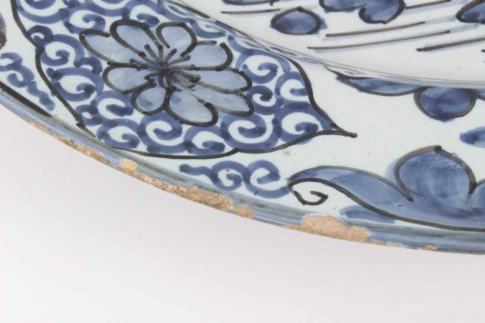 A blue and white Dutch delftware dish, circa 1700, painted in the Oriental style with birds amongst - Image 5 of 9