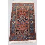 Small Eastern rug, with central serated medallion on brick red ground, in main meander border, 180 x