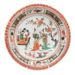 A Chinese famille verte plate, Kangxi period, decorated with two courtesans in a garden, pie crust r