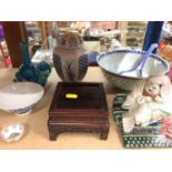 Group of Oriental ceramics including bowls, vases, seated figure ornament and a hardwood stand