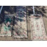 Three Chinese wash rugs with floral decoration on green ground, 220cm x 70cm, 160cm x 76cm and 128cm