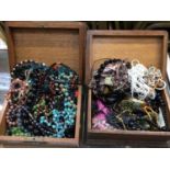 Two wooden jewellery boxes containing various bead necklaces