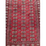 Eastern rug with geometric decoration on red ground, 185cm x 119cm