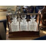 Edwardian tantalus with three hobnail cut glass decanters in silver mounted oak case