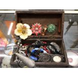 Small wooden box of costume jewellery and a magnifying glass