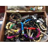 Wooden box containing two gold pendants and chain, quantity of bead necklaces, wristwatches and othe