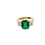 A fine emerald and diamond three stone ring