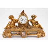 19th century French gilt brass mantel clock with inset porcelain panels, twin putti mounts and centr