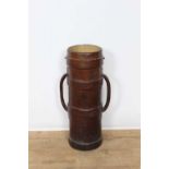Antique brown leather artillery shell carrier, with flanking handles, 75cm high