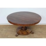 Regency rosewood circular breakfast table, the circular tilt-top raised on tapered facetted column a