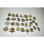 Collection of thirty military cap badges to include Carnarvonshire Volunteer Regiment, The Buffs and