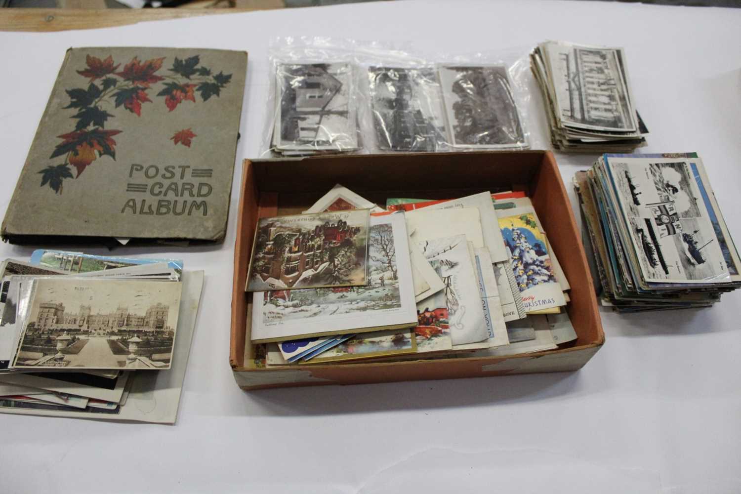 Postcards in album and loose. Good selection of real photographic cards including animated street sc