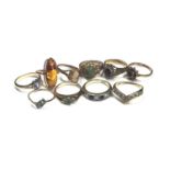 Seven 9ct gold gem set dress rings, gold (583) amber ring, gold (333) blue stone ring and a yellow m