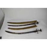 Two 19th century Indian Tulwar swords with steel disc hilts, curved blades with associated scabbards