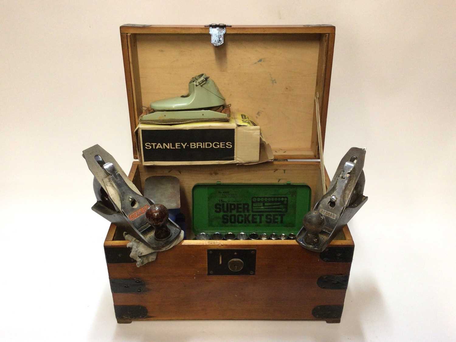 A Stanley plane, a Record plane, a Stanley Bridges sander, a socket set, etc, in a wooden tool box