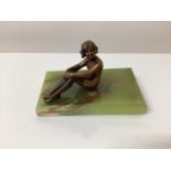 Art Deco bronze figure of a seated nude woman in stockings, on a green onyx base, 12.5cm in length.