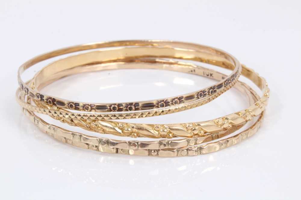 Five gold/yellow metal bangles