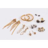 Seven pairs of 9ct gold and yellow metal earrings including gem set studs, hoops etc