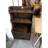 A 61cm vintage Ercol dark elm three shelf waterfall bookcase with shaped sides and double cupboard