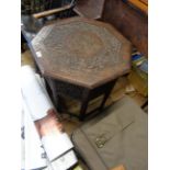 An Eastern hardwood occasional table with brass inlay and carved floral decoration to top, set on