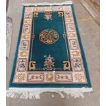 A modern handmade Chinese washed wool rug with central medallion and floral panels on green ground -