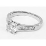 A platinum 0.9ct. diamond solitaire ring with further diamonds to shoulders - complete with E.G.L.