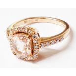 A marked 750 rose metal ring, set with central cushion cut morganite within a diamond encrusted
