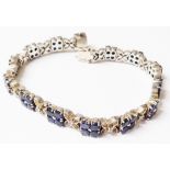 A boxed white metal fancy-link bracelet, each of the links set with four small sapphires