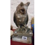 A vintage plaster model of a wise owl standing on a book with glass eyes and sponged paint finish