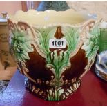 A late 19th Century majolica pottery jardiniere decorated with applied face masks and swags with