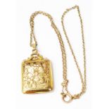 A vintage yellow metal oblong locket with engraved decoration, on chain