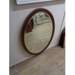 An Edwardian mahogany and strung bevelled oval wall mirror