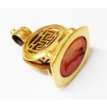 An old yellow metal fob seal with Greek key pierced decoration and carved intaglio carnelian panel