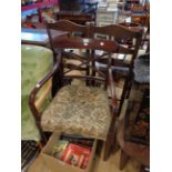 A stained mahogany framed Regency elbow chair with X-frame back and remains of upholstery - old