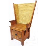 A vintage Orkney mixed wood lambing chair with woven and bound rush flared wing back, panelled