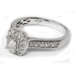 An import marked 950 (Platinum) ring, set with central square cut diamond within a diamond encrusted