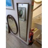 A wood and brassed metal bound framed narrow oblong wall mirror