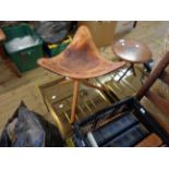 A vintage American collapsible saddle stool with hide seat set on tripod base, made by Chamlers,