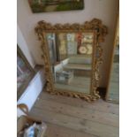 An ornate giltwood style bevelled oblong wall mirror with pierced acanthus scroll border